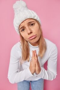 Propietaria de clínica dental haciendo gesto de "por favor" para pedir una reseña a paciente